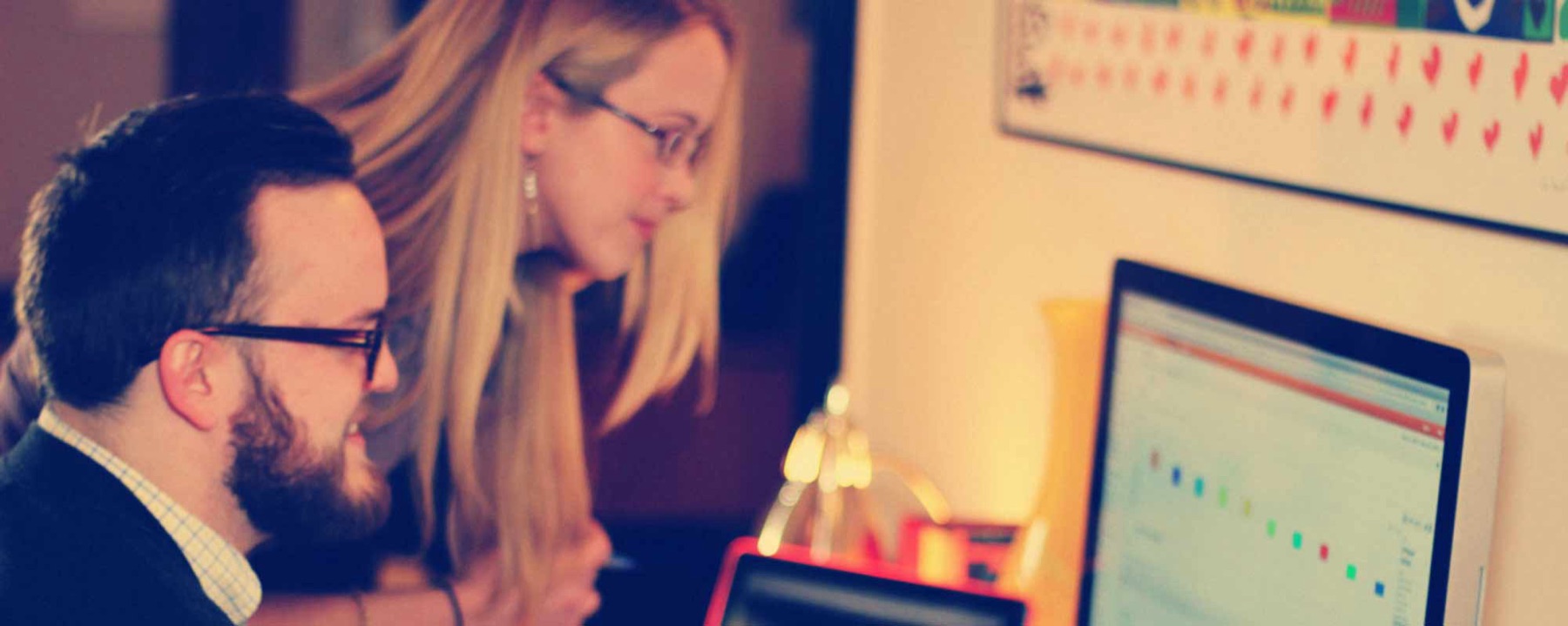 Backbone Media team members reviewing work at a desk